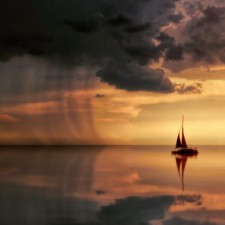 A sailboat is in the middle of a lake at sunset and a storm approaches with lightings and thunders.